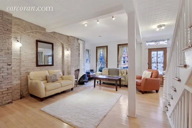 $1.65M brick townhouse in South Slope has a sunroom and a lush garden with a pond