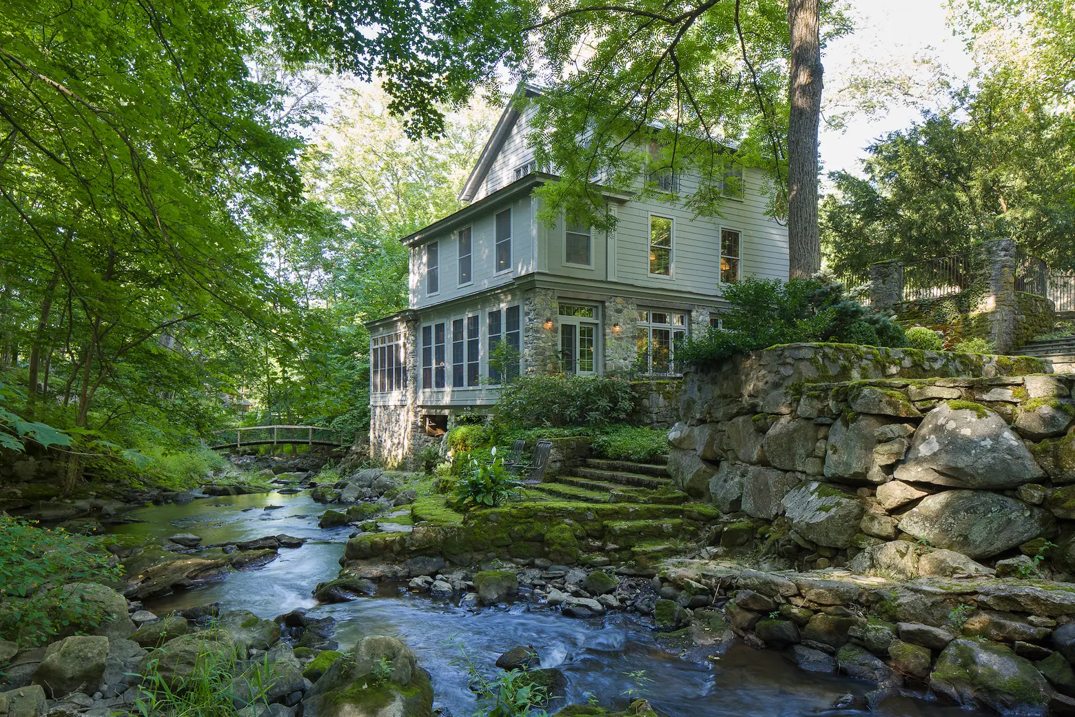 For $2.8M, this 1840s upstate millhouse has a private waterfall, terraced gardens, and a gorgeous pool