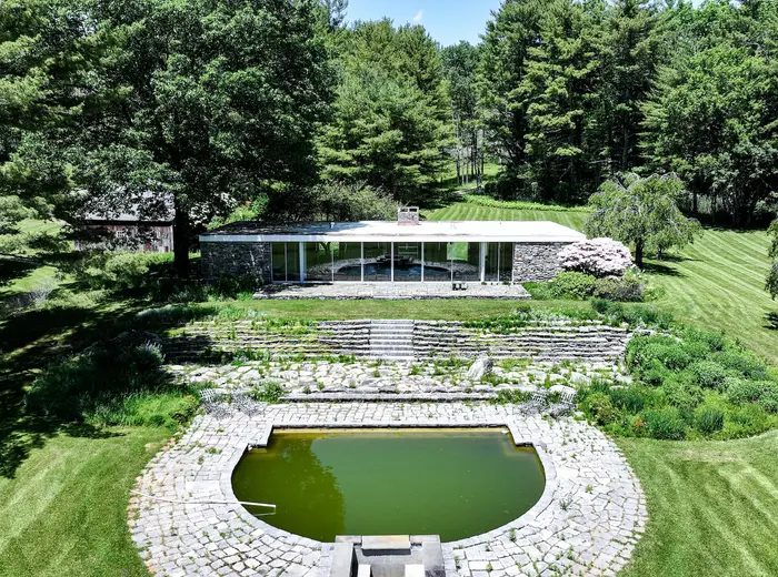 This 1969 stone-and-glass modern house on 25 Connecticut acres is a 'fire sale' listing for $1.3M